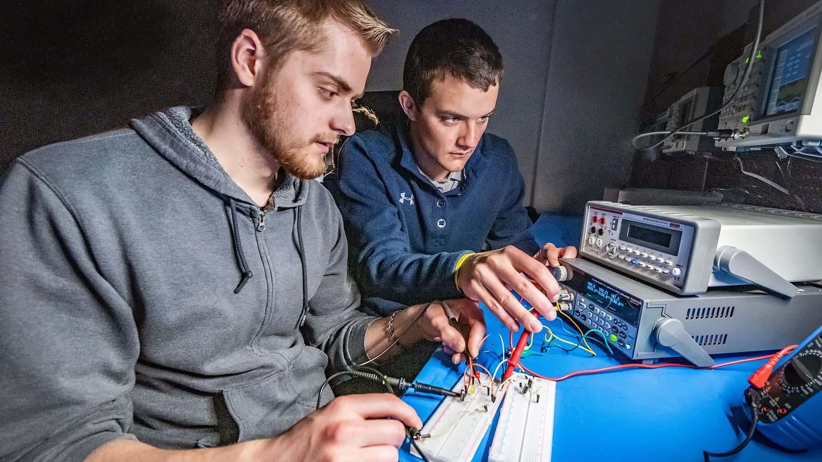 Two electrical engineering students working on project