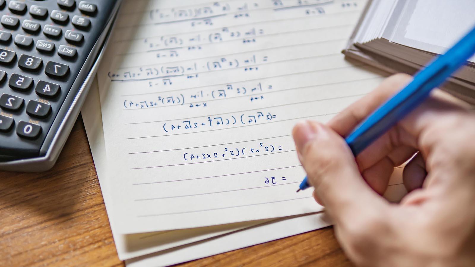 A left-handed person solving math problems.
