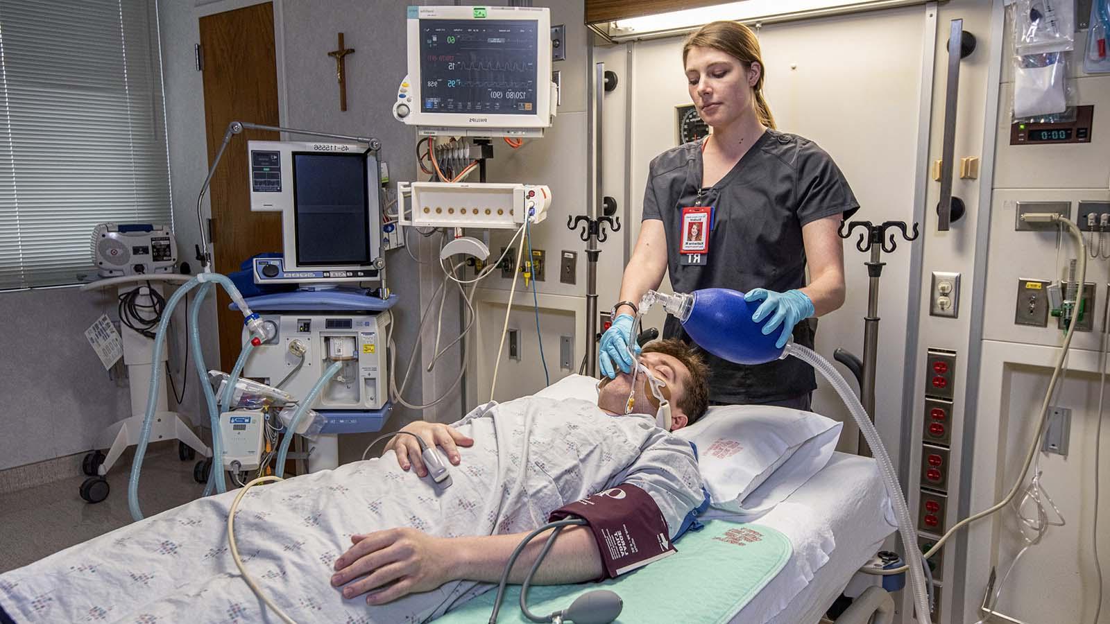 Respiratory therapist intubating patient in hospital