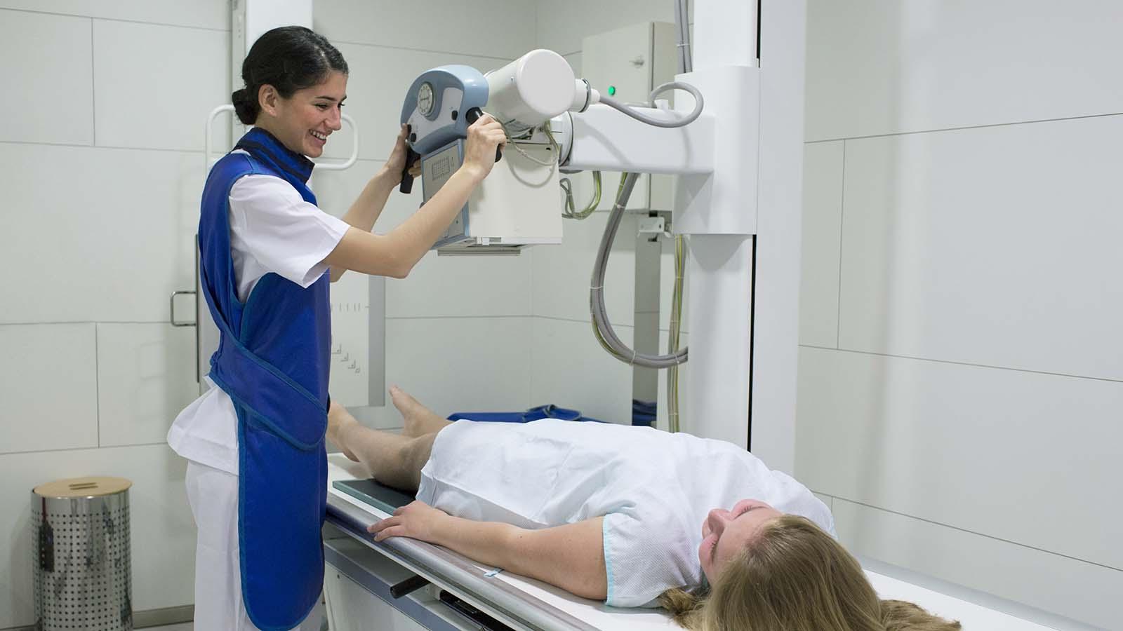 Radiologist with patient preparing machine for x-ray